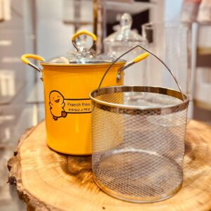 حلة تيفال بطوط 5 لتر بلون أصفر مع سلة ستانلس وغطاء معدني على سطح المطبخ.