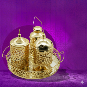 صينية بمجموعة مزخرفة لرمضان، تشمل مبخرة وفانوس وبرطمان تمر، مصنوعة من معدن مطلي بلون دهبي.